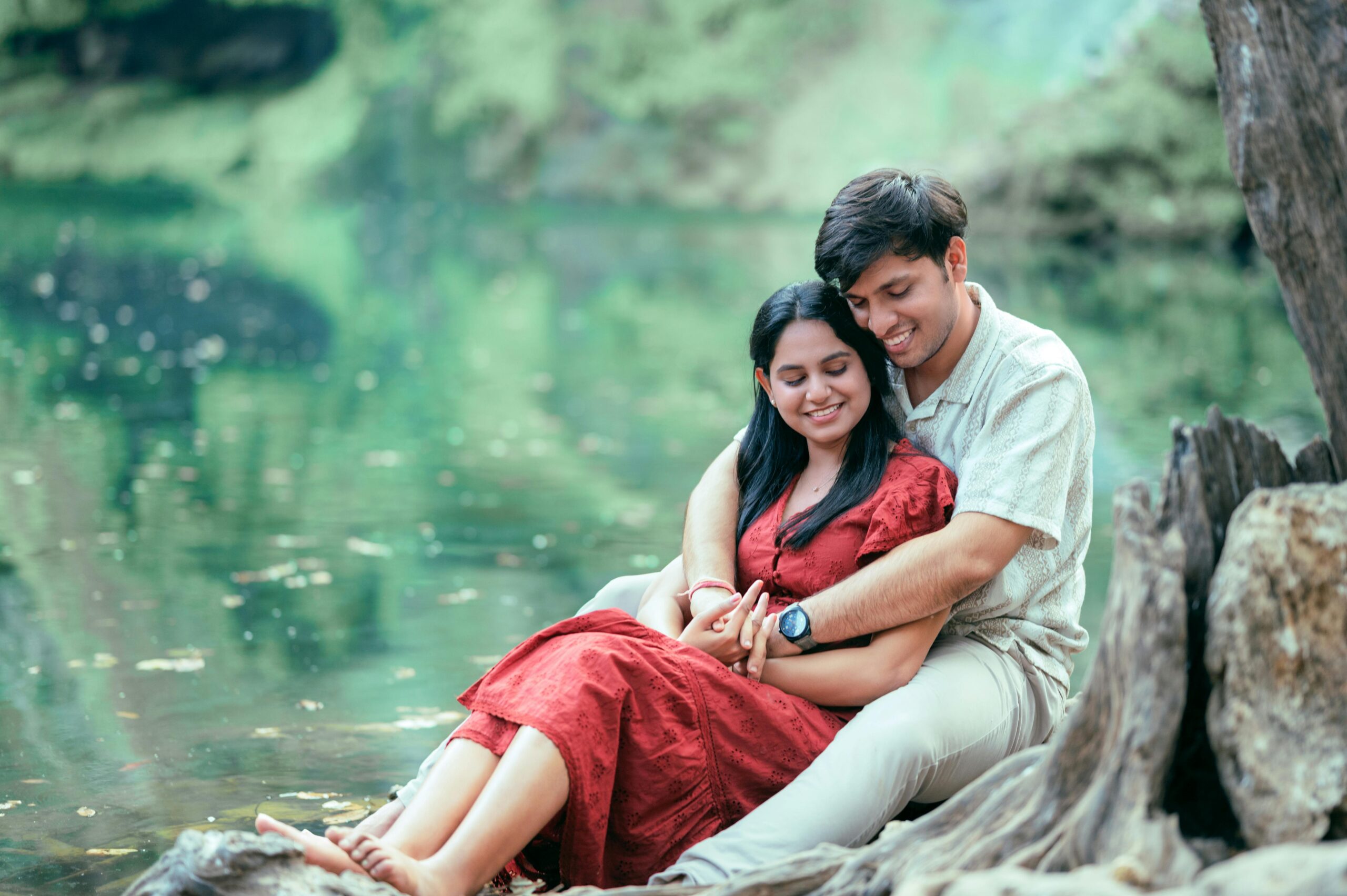 A couple embraces lovingly by a tranquil lakeside, exuding romance and serenity.