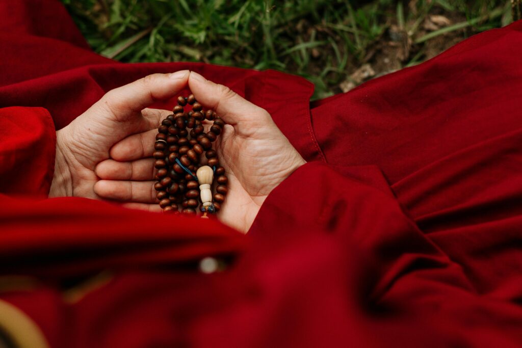 Close-up of hands holding prayer beads, symbolizing spirituality and meditation.